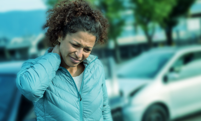 A woman holds her neck after an accident