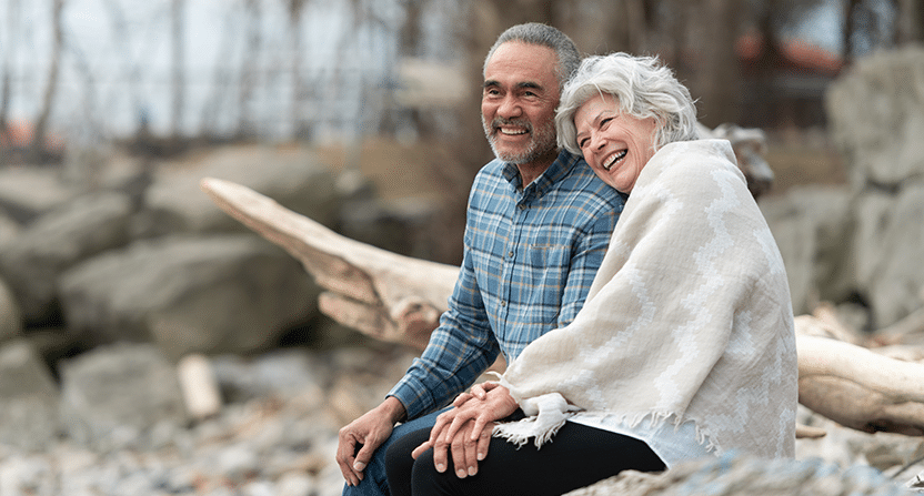 Senior couple cuddling at the beach.